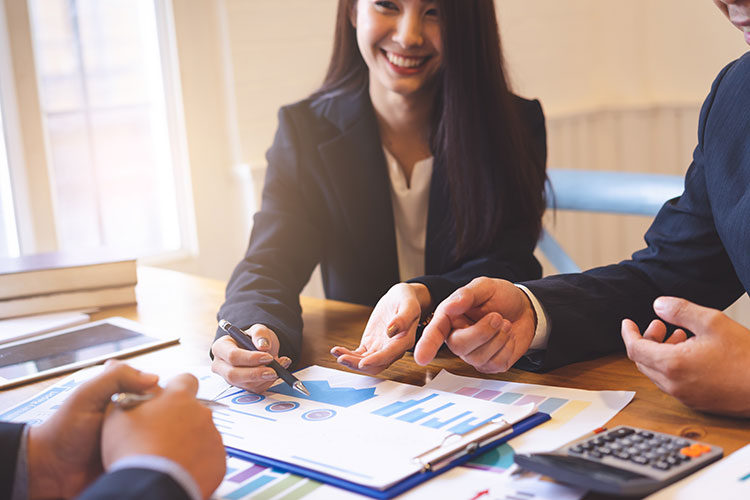 business people discussing financial papers and graphs on a table