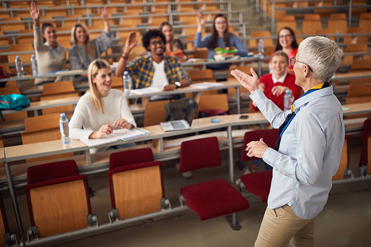professor asking a question to class and students raising hands