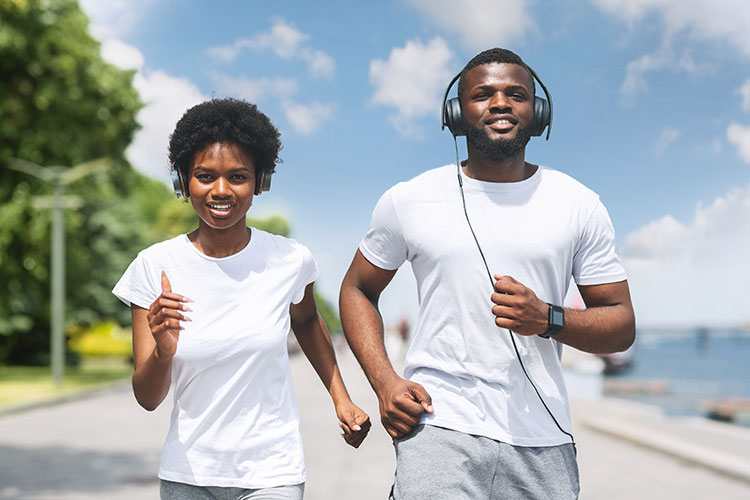 two young african american people going out for a run while listening to music