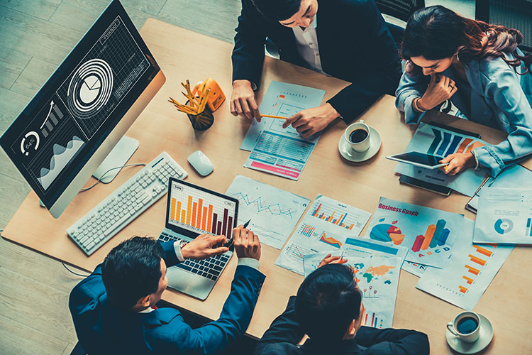 business people discussing finances with various graphs and papers on the office desk