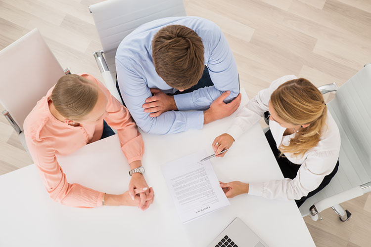 bird's eye view of three businesspeople discussing a contract